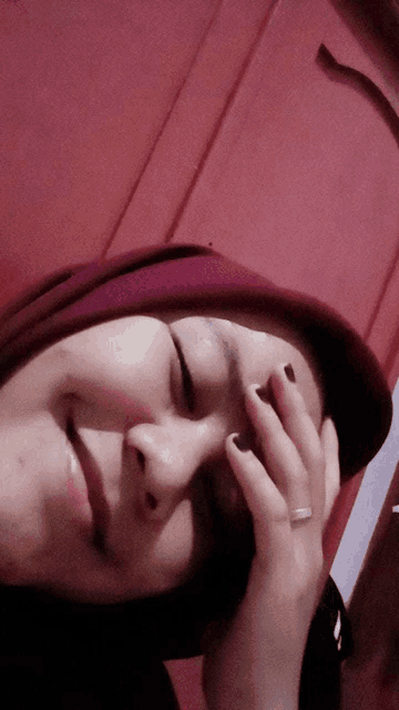 a woman covering her face with her hand with a ring on her finger
