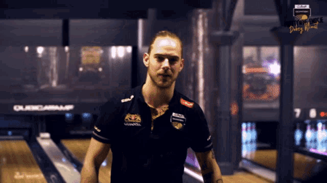 a man stands in front of a bowling alley with a sign that says ' quickcabamp ' on it
