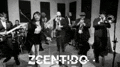 a black and white photo of a group of people dancing and singing in a room .
