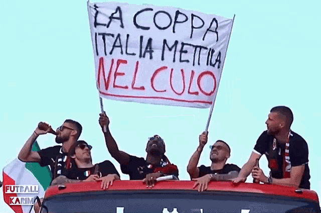 a group of men are holding up a banner that says la coppa italia mettia nel culo