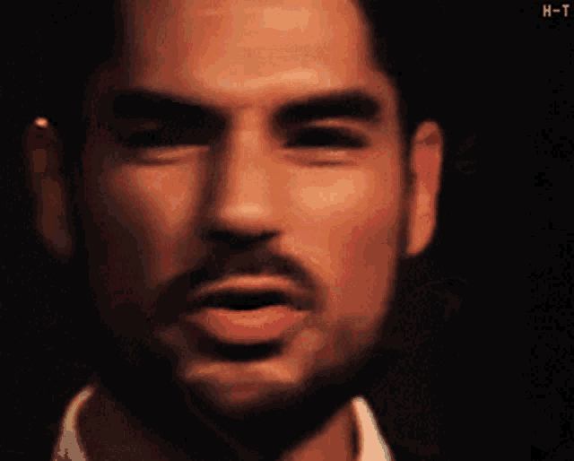 a close up of a man 's face with the letter h-t visible