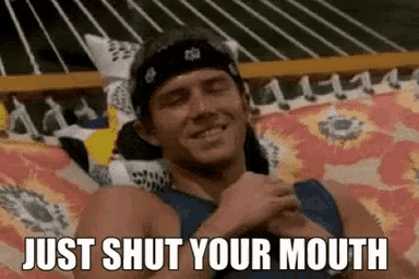 a man with a bandana on his head is sitting on a hammock and says just shut your mouth