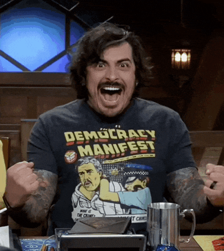 a man wearing a democracy manifest t-shirt is making a face