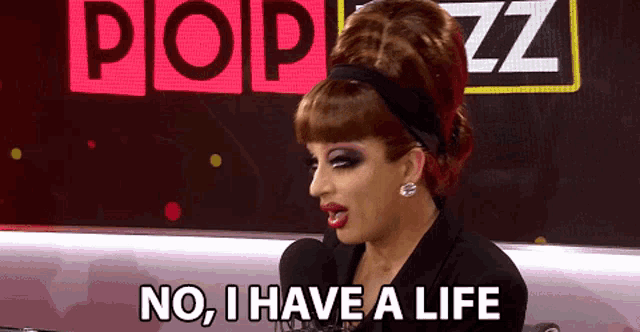 a drag queen says " no i have a life " while sitting in front of a microphone