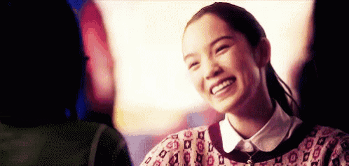 a young woman is smiling while talking to another woman .