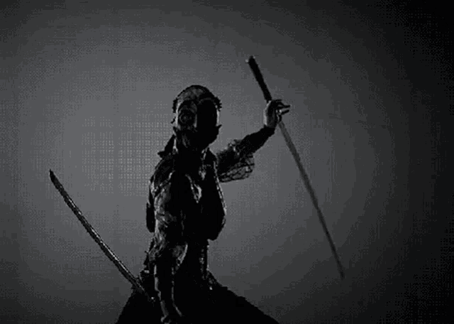 a black and white photo of a samurai holding a sword in his hand .