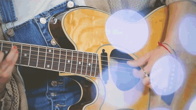 a person is playing a guitar with a blurred background