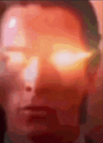 a close up of a person 's face with glowing red eyes