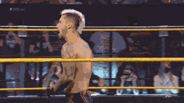 a man in a wrestling ring with the hashtag # 205live on the bottom