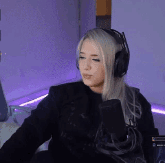 a woman wearing headphones is talking into a microphone .