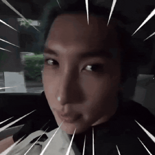 a close up of a person 's face in a car with rays coming out of his eyes .
