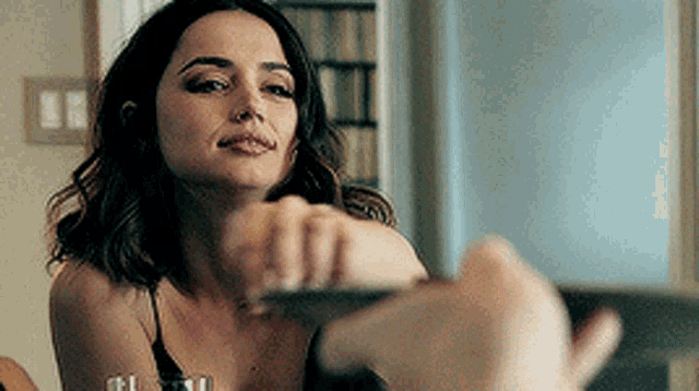 a woman in a black tank top is sitting at a table with a man .