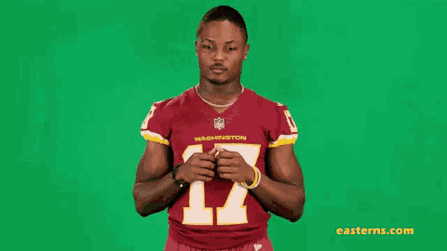 a washington redskins football player is giving a thumbs up .