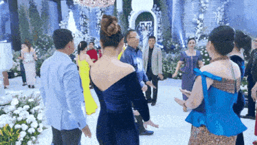 a group of people are dancing in a circle at a party