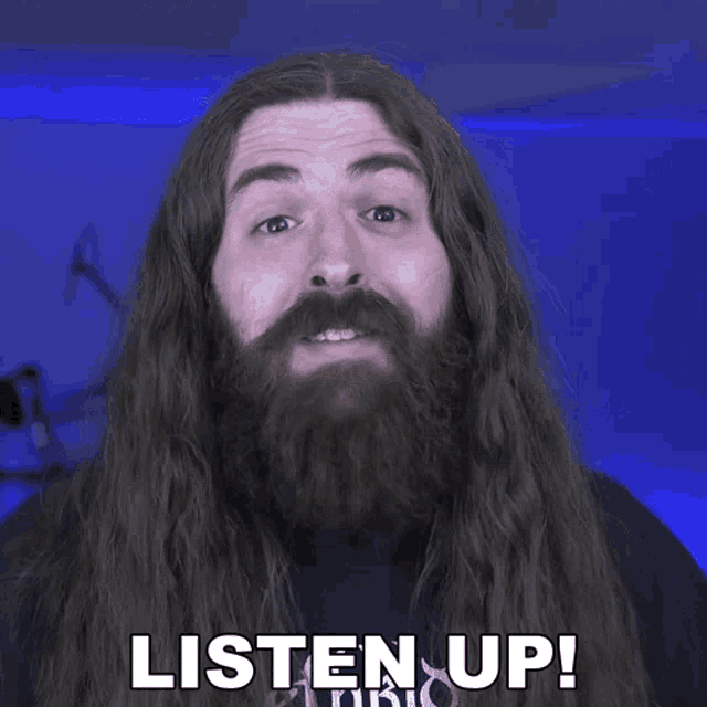 a man with long hair and a beard has the words listen up on his face