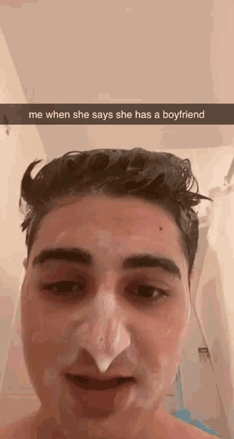 a man is taking a selfie with foam on his face and says me when she says she has a boyfriend .