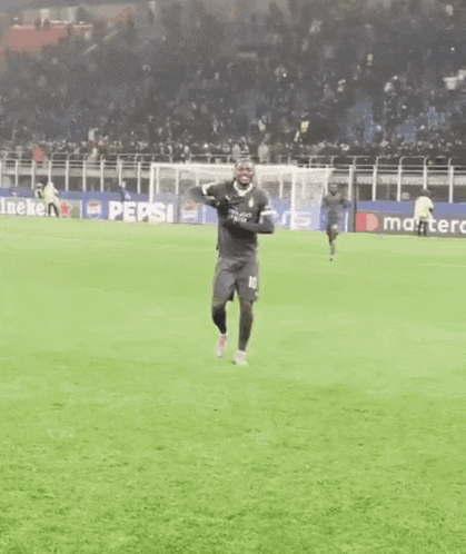 a soccer player wearing a number 10 jersey is dancing on the field