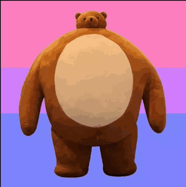 a large brown teddy bear with a big belly is standing on a pink and blue background .