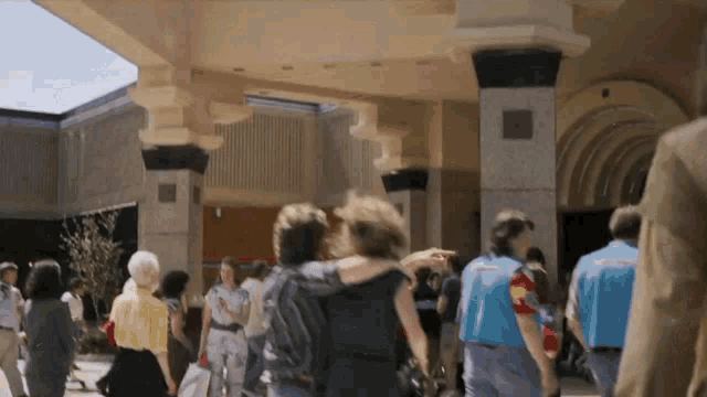 a group of people are walking in front of a building with the number 8 on it