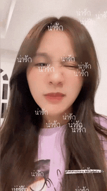 a close up of a woman 's face with the word นา รัก written on it