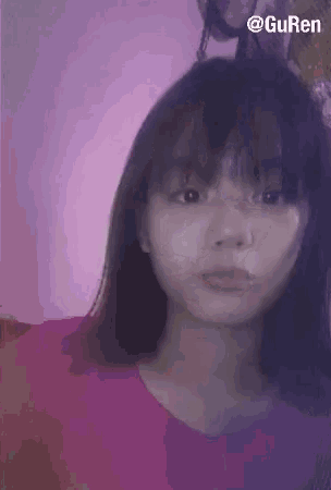 a girl in a pink shirt is taking a selfie with a pink background