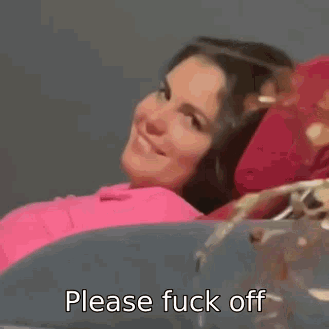 a woman is laying on a couch with the words `` please fuck off '' written on the bottom .