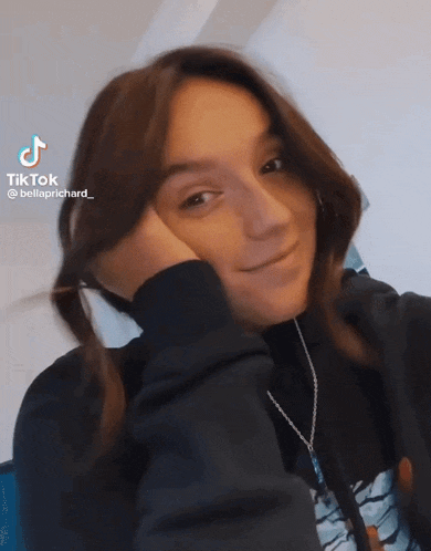 a woman is taking a selfie with her hand on her face ..
