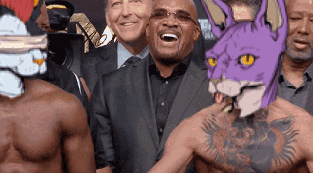 a man with a purple cat on his head is laughing