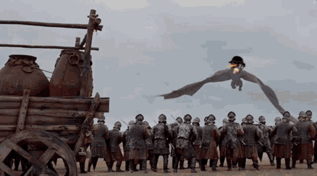 a dragon flying over a group of soldiers