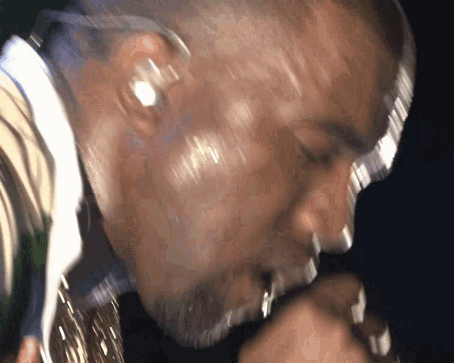 a man singing into a microphone with earbuds in his ears