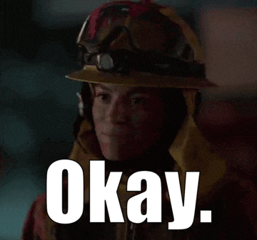 a woman wearing a hard hat says okay in white letters