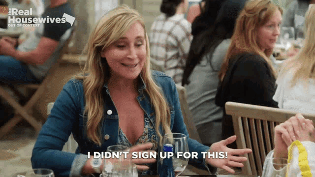 a woman is sitting at a table with a sign that says real housewives