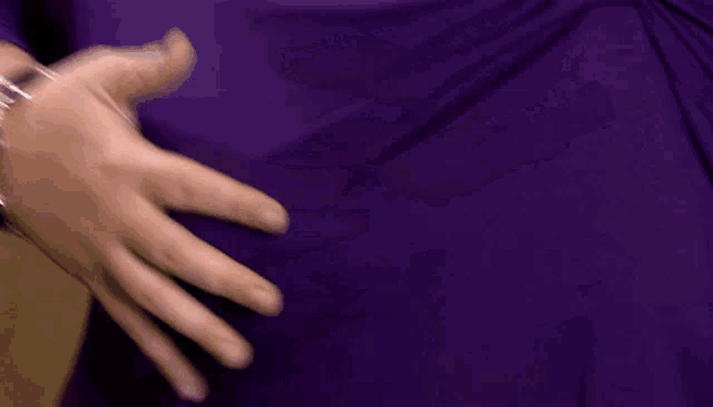 a blurry picture of a person 's hands on a purple background