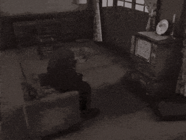 a man in a suit is standing in a living room next to a television .