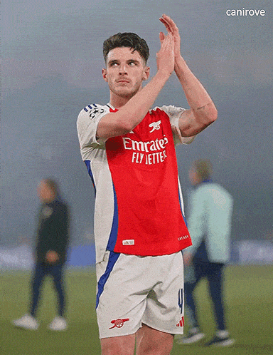 a soccer player wearing a red emirates fly jetters jersey