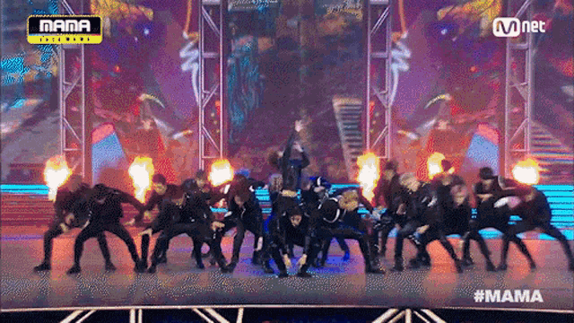 a group of people are dancing on a stage with a mnet logo above them