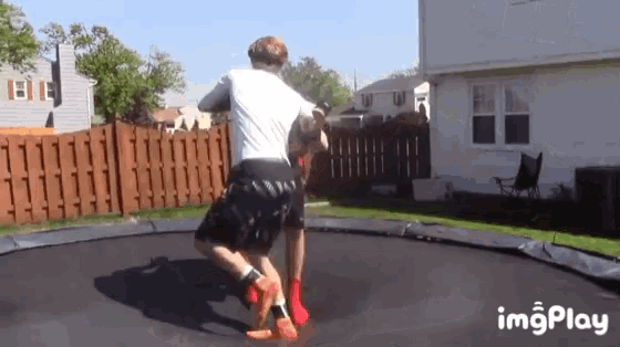 two men are wrestling on a trampoline with the imgplay logo in the background