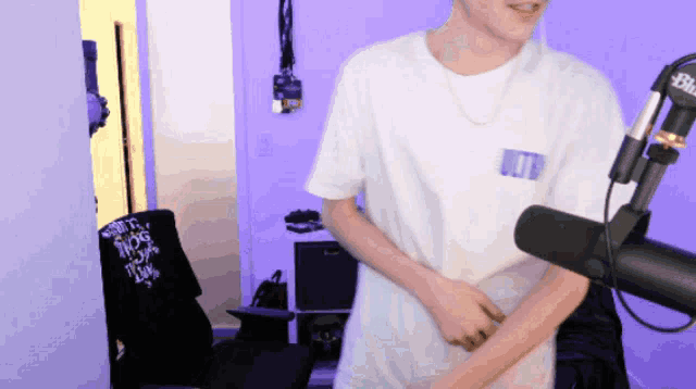 a man is standing in front of a microphone with a shirt that says " i love you " on it