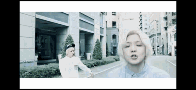 a man with blonde hair is walking down the street