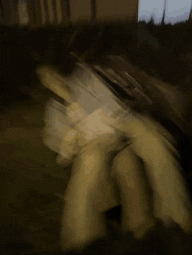 a blurry picture of a person in a white shirt in the dark