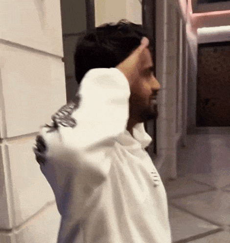 a man wearing a white shirt that says ' you ' on the sleeve