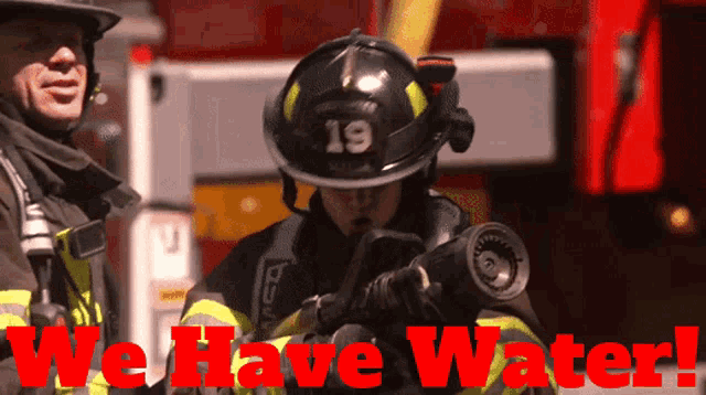 a fireman with the number 19 on his helmet is spraying water