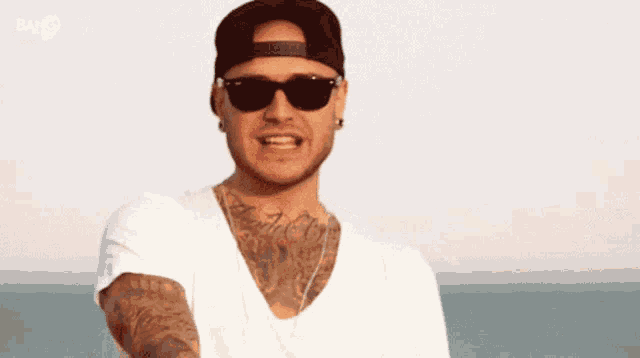 a man wearing sunglasses and a hat with the word bay on the bottom right