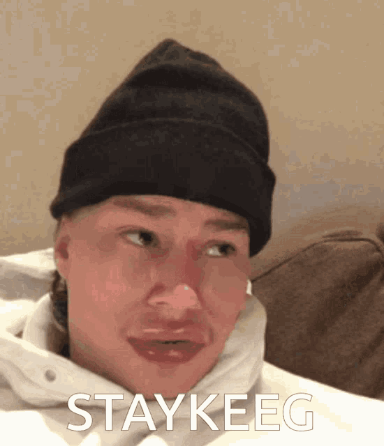 a man wearing a black beanie has the word staykeeg on the bottom