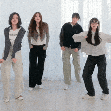 four girls are dancing and one of them has a shirt that says tiger on it