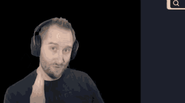 a man wearing headphones and a shirt that says extinct is pointing