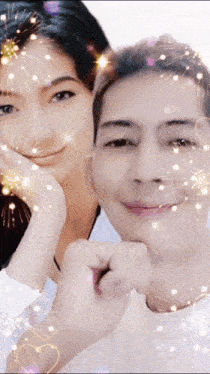 a man and woman are posing for a picture with fireworks behind them