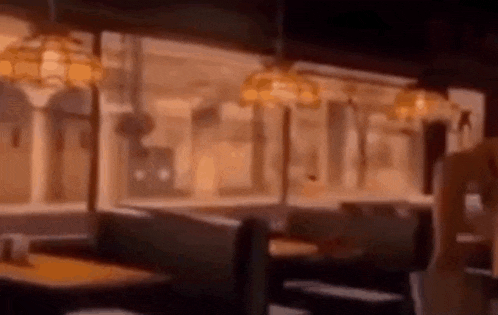 a blurry picture of a diner with tables and chairs and lamps .