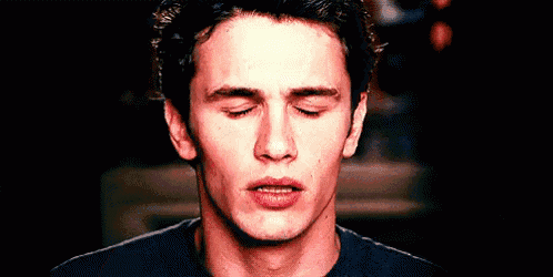 a man with his eyes closed is wearing a black shirt .