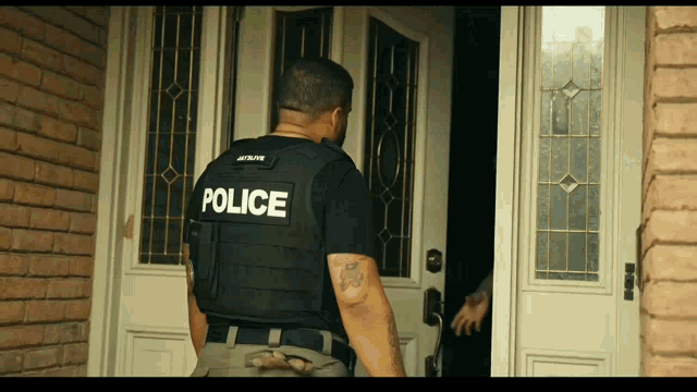a man in a black vest with the word police on the back